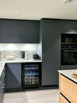 a kitchen with black cabinets and an open refrigerator at Charming & Modern Seaside House In Valsøyfjord in Valsøyfjord