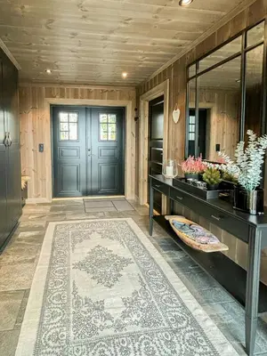 a hallway with a blue door and a rug at Architect Mountain Cabin At Lygna With Views in Jaren