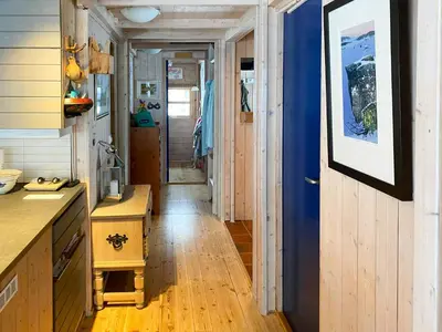 a hallway in a tiny house with a blue door at Modern Mountain Cabin Near Hiking Terrain in Geilo