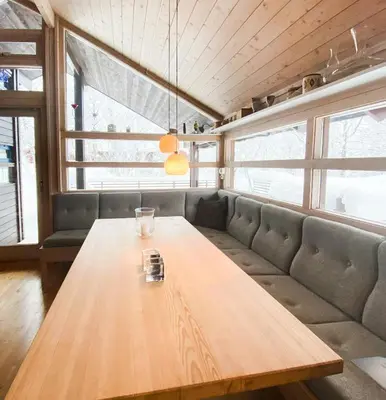 a dining room with a wooden table and a couch at Modern Mountain Cabin Near Hiking Terrain in Geilo