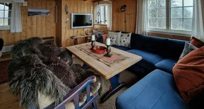 a living room with a blue couch and a table at Charming Cabin With Views In Valdres in Aurdal