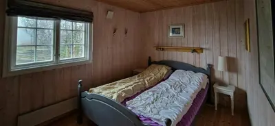 a bed in a corner of a room with a window at Charming Cabin With Views In Valdres in Aurdal