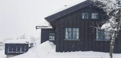 a house covered in snow with a pile of snow at Charming Cabin With Views In Valdres in Aurdal