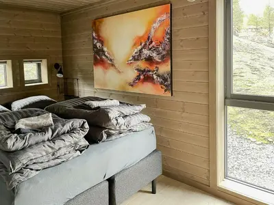 a room with two beds and a painting on the wall at Modern Cabin With Panoramic View On Bringsfjellet in Lalm