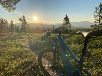 a bike parked on a trail with the sunset in the background at Unique Hobbit Cabin By Hallingskarvet in Hovet