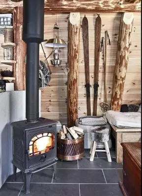 a woodburning stove in a room with a bedroom at Unique Hobbit Cabin By Hallingskarvet in Hovet