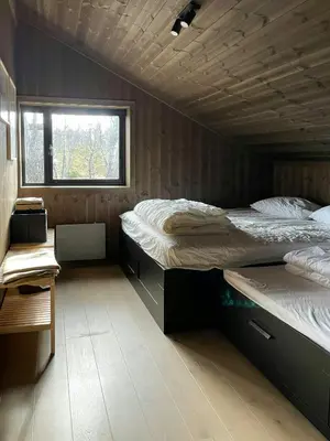 two beds in a small room with a window at Spacious Mountain Cabin With Fantastic Views in Ål