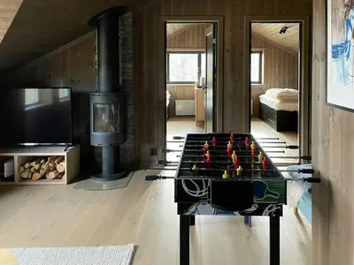 a living room with a foosball table in front of a fireplace at Spacious Mountain Cabin With Fantastic Views in Ål