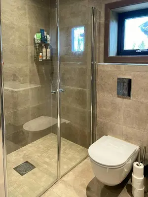a bathroom with a shower with a toilet and a window at Spacious Mountain Cabin With Fantastic Views in Ål