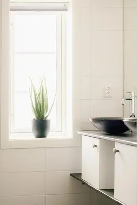 a bathroom with a sink and a window with a plant at Unique House On The Waterfront On Veiholmen in Smøla