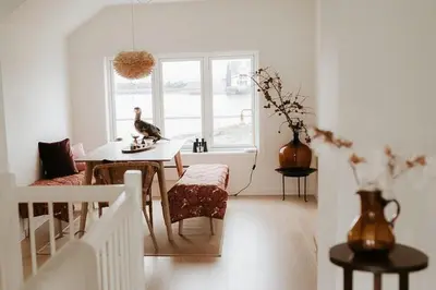 a white living room with a table and a vase at Unique House On The Waterfront On Veiholmen in Smøla