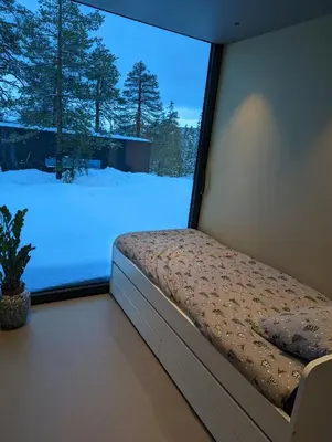 a bed in a room with a window with snow at Modern Cabin By Snøhetta At Blefjell in Svene