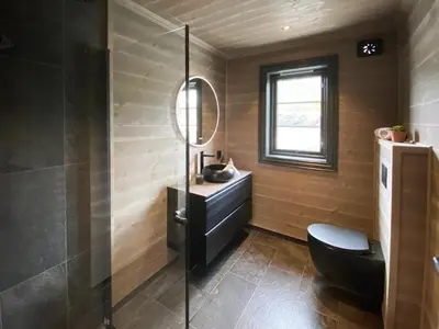 a bathroom with a black toilet and a sink at Adventure And Relaxation In Voss in Vossevangen