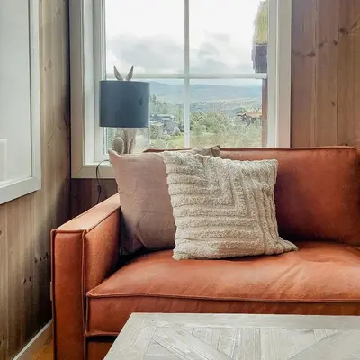a brown leather couch sitting in front of a window at Unique Cabin By The Ski Slope In Hovden in Hovden