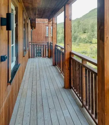 a wooden porch on a cabin with a view of the mountains at Unique Cabin By The Ski Slope In Hovden in Hovden