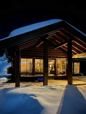 a building with glass windows in the snow at Nature-Close Cabin By The Water in Eggedal