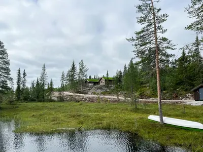 a house on a hill next to a body of water at Nature-Close Cabin By The Water in Eggedal