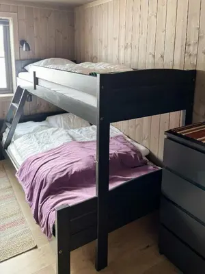 a bedroom with a bunk bed with purple sheets at Nature-Close Cabin By The Water in Eggedal