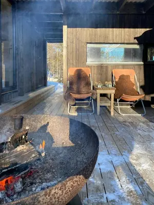 a living room with two chairs and a fire pit at Mountain Cabin With Sauna At Blefjell in Lampeland