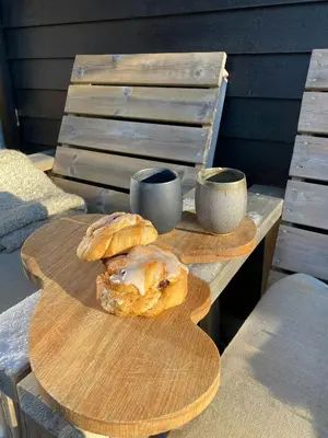 a wooden table with two pastries and two cups on it at Mountain Cabin With Sauna At Blefjell in Lampeland