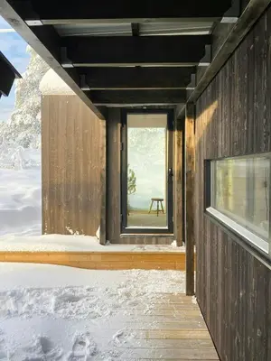 a wooden house in the snow with a window at Mountain Cabin With Sauna At Blefjell in Lampeland
