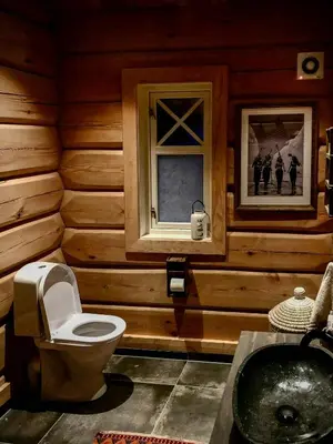 a wooden bathroom with a toilet and a sink at Rustic Log Cabin At The Foot Of Hardangervidda in Uvdal