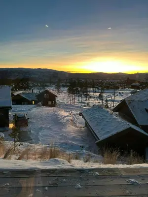 a snow covered yard with the sun setting in the distance at Cabin With Panoramic Views In Turufjell in Flå