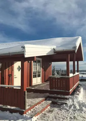 a red building with snow on top of it at Charming Cabin With Fantastic View In Sjusjøen in Sjusjøen