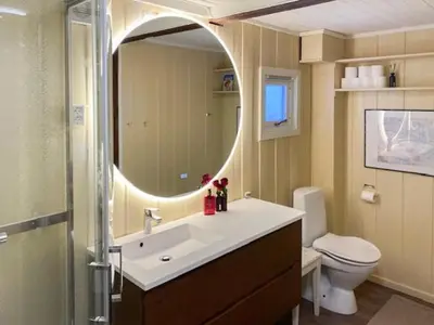 a bathroom with a sink and a toilet and a mirror at Charming Cabin With Fantastic View In Sjusjøen in Sjusjøen