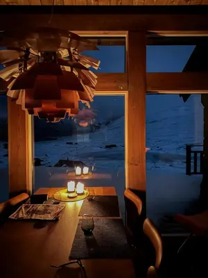 a dining room with a view of the ocean at night at Spectacular Cabin With View In Jotunheimen in Eidsbugarden