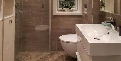 a bathroom with a shower and a toilet and a sink at Seaside Dream Cabin With Jacuzzi in Steinsland