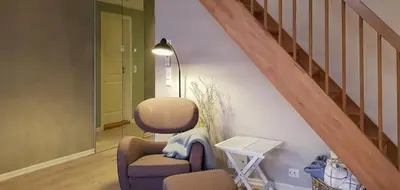 a living room with a chair and a staircase at Seaside Dream Cabin With Jacuzzi in Steinsland