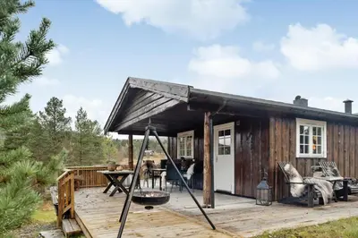 a tiny house with a porch and a deck at Old Swiss Hotel Charm In Seljestad in Vinjeøra