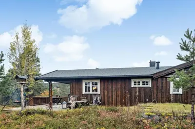 a log cabin with a porch and a deck at Old Swiss Hotel Charm In Seljestad in Vinjeøra