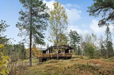 a house in the middle of a field with trees at Old Swiss Hotel Charm In Seljestad in Vinjeøra