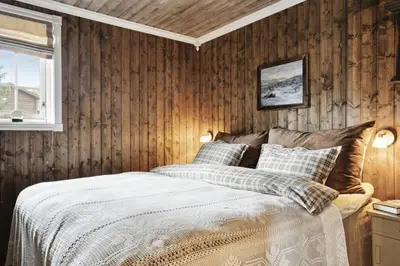 a bedroom with wood paneled walls and a bed at Old Swiss Hotel Charm In Seljestad in Vinjeøra