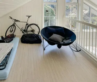 a room with a chair and a bike in a room at Cozy Family Cabin Surrounded By Idyllic Islands in Fitjar