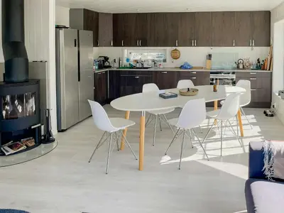 a kitchen with a white table and white chairs at Cozy Family Cabin Surrounded By Idyllic Islands in Fitjar