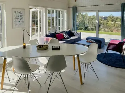 a living room with a white table and chairs at Cozy Family Cabin Surrounded By Idyllic Islands in Fitjar
