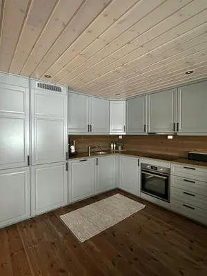 a kitchen with white cabinets and a wooden ceiling at Family Cabin With Ski Inout At Furutangen in Vika