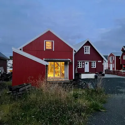 a red barn with a window in a field at Seaside Boathouse In Veiholmen in Smøla