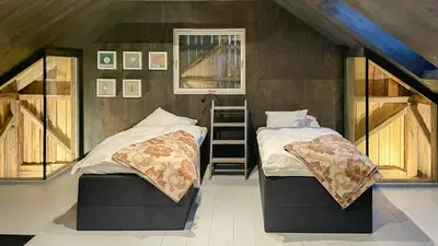 a bedroom with two beds and a ladder in it at Seaside Boathouse In Veiholmen in Smøla