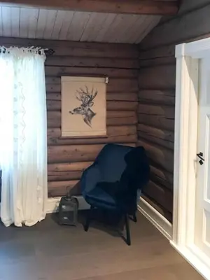 a chair sitting in a room with a window at Mountain Cabin With A View Over Jotunheimen in Tretten