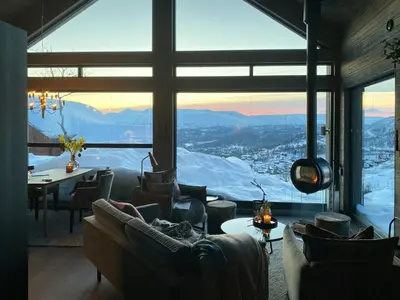 a room with couches and a table and a large window at Cabin With Panoramic And Ski Trails Outside in Rauland