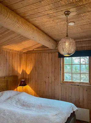 a bedroom with a bed and a window and a lamp at Family Fun Cabin In Engerdals Heart in Nymoen