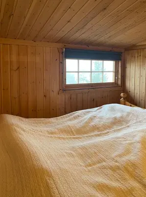 a bed in a wooden room with a window at Family Fun Cabin In Engerdals Heart in Nymoen