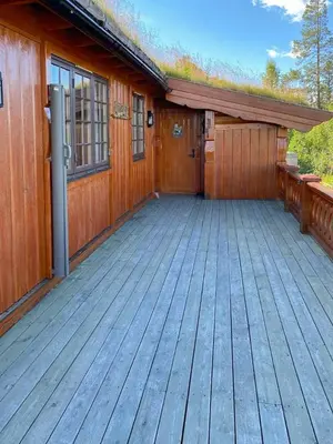 a house with a wooden porch with a deck at Family Fun Cabin In Engerdals Heart in Nymoen
