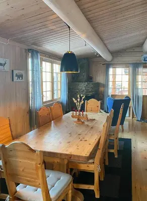 a dining room table with chairs and a large wooden table at Family Fun Cabin In Engerdals Heart in Nymoen