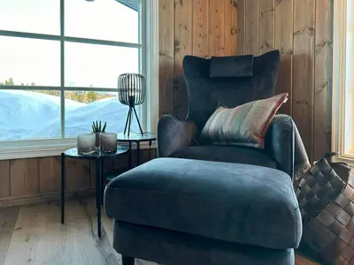 a living room with a chair and a table at Cabin With Panoramic View In Synnfjell in Nord Torpa