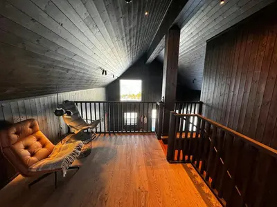a living room with a couch and a wooden wall at Modern Apartment Overlooking Gudbrandsdalen in Øyer